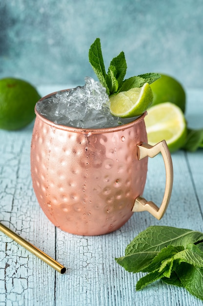 Copper mug of Moscow mule cocktail garnished with mint and lime