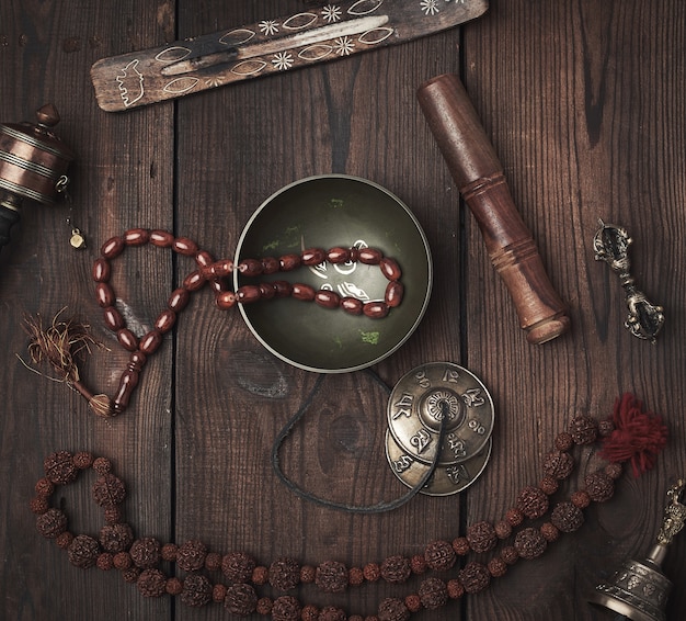 Copper singing bowl, prayer beads, prayer drum and other Tibetan religious objects for meditation and alternative medicine