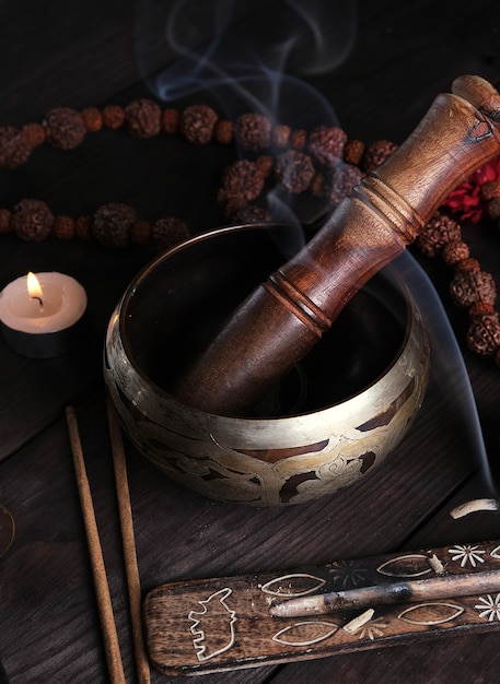  copper singing bowl and a wooden stick on a brown table