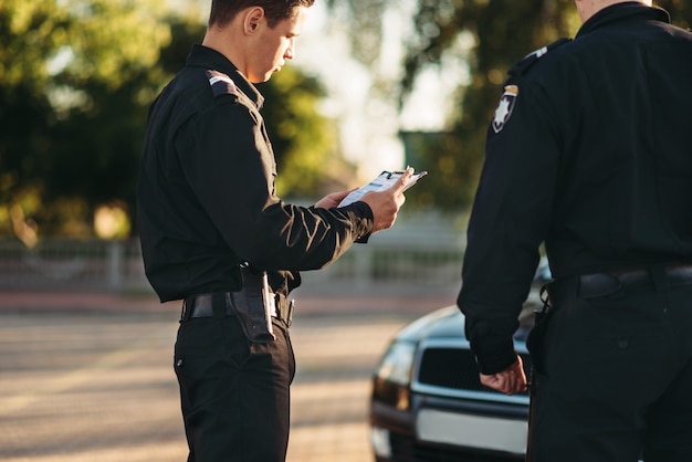 Cops in uniform stop the car on road