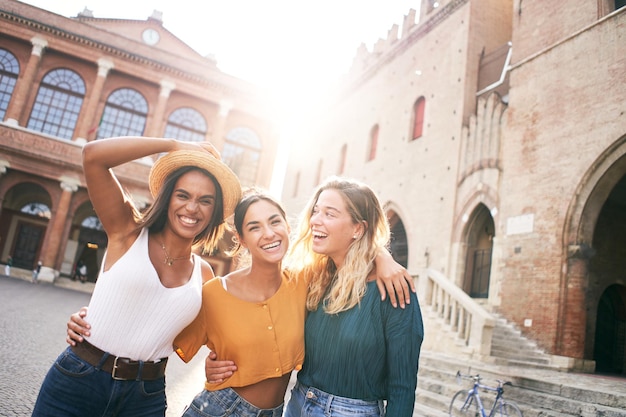 Copy space portrait of a three women looking at the camera the girls are standing in the square of a...