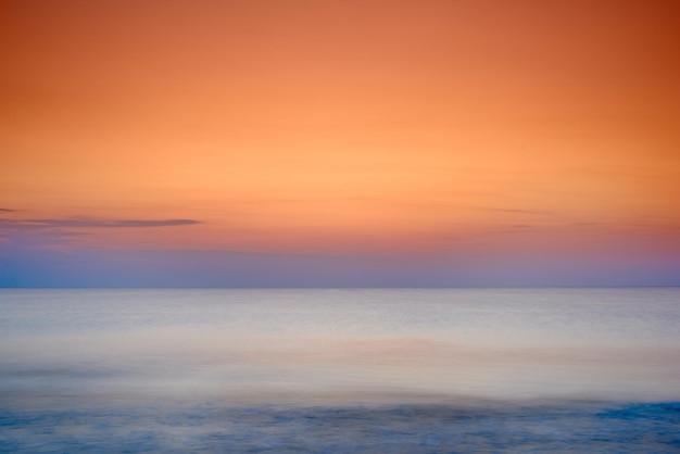 Copyspace seascape of an orange sunset on the west coast of Jutland in Loekken Denmark Sun setting on the horizon on an empty beach at dusk over the ocean and sea at night Sunrise in the morning