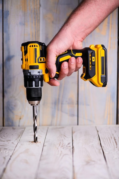 Photo cordless drill and a drill on a wooden background