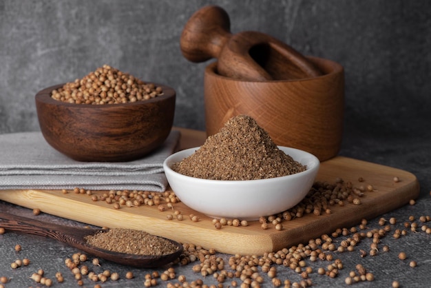 Coriander grains and coriander powder in a wooden bowl Coriander seeds Coriander spice