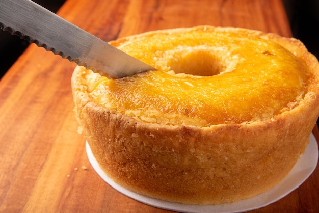 Corn cake on a styrofoam tray and a knife on a rustic wooden surface selective focus