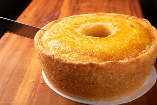 Corn cake on a styrofoam tray and a knife on a rustic wooden surface selective focus