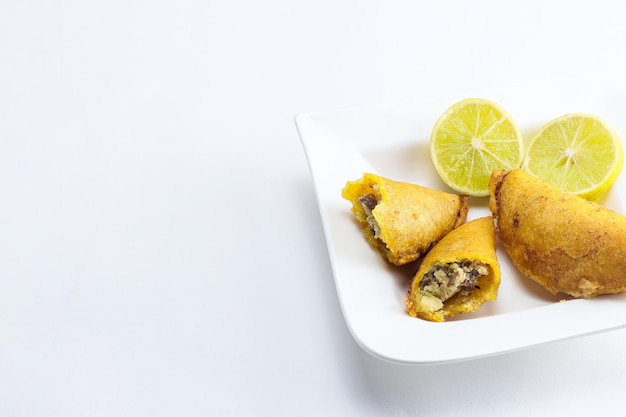 Corn empanada typical Colombian food with spicy sauce and lemon with copy space