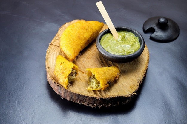 Corn empanada typical Colombian food with spicy sauce