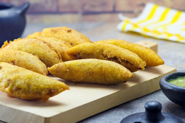 Corn empanada typical Colombian food with spicy sauce