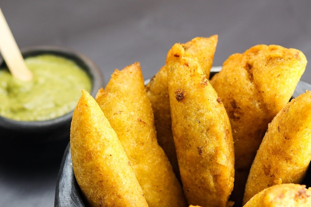 Corn empanada typical Colombian food with spicy sauce