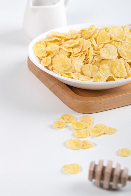 Corn flakes bowl sweeties with milk and orange on white background close up fresh and healthy breakfast design concept