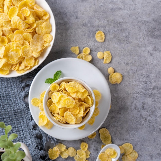 Corn flakes bowl sweets on gray cement background top view flat lay layout design fresh and healthy breakfast concept