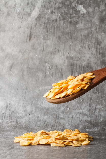 Corn flakes on a wooden stone and on stone background with copy space