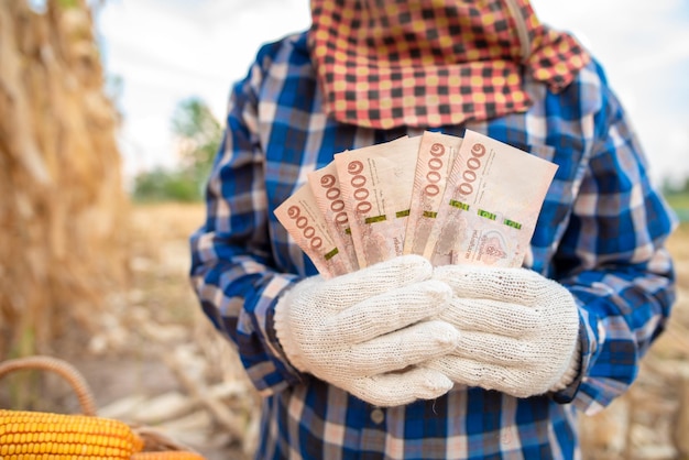 Corn growers hold Thai banknotes worth 5000 baht Concept Farmers receive government grants