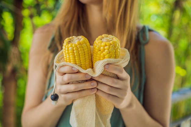 Corn in a reusable bag in the hands of a young woman Zero waste concept