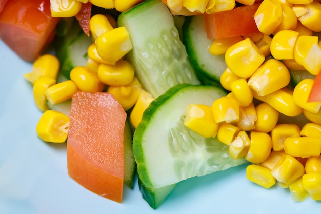 Corn salad, tomato and cucumber with olive oil. Food is proper nutrition. Vegetarian food