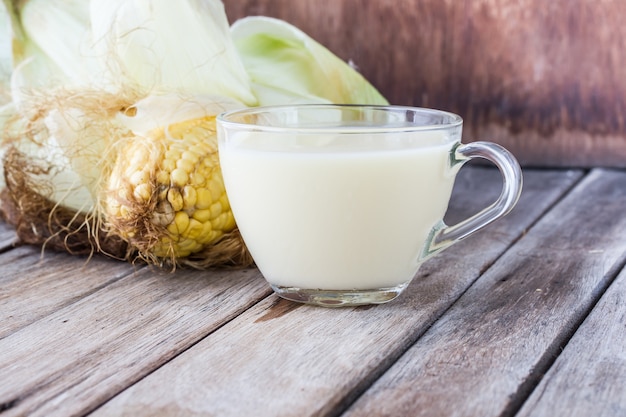 Corn water in a glass on a wood table