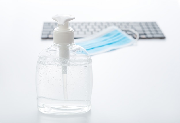 Coronavirus Covid Prevention. Hand sanitizer antiseptic gel, respiratory protective mask, surgical disposable masks for protection from viruse on computer keyboard.