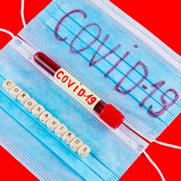 Coronavirus COVID19 Test tube with blood identified by the COVID19 coronavirus on red background