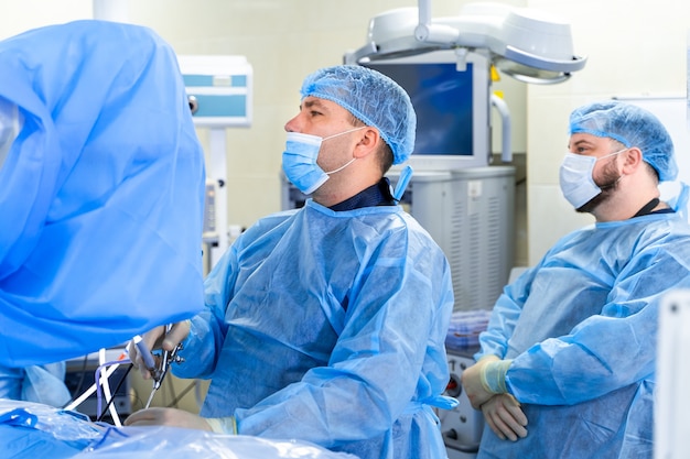 Coronavirus. Doctors and nurses working in the hospitals. Fighting the coronavirus. Male doctor in the protective suit and mask looking at screen. Vaccine. Heroes.