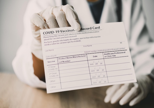 Coronavirus vaccination record card in the hands of a doctor to a patient who has already been vaccinated with Coronavirus. .Coronavirus prevention