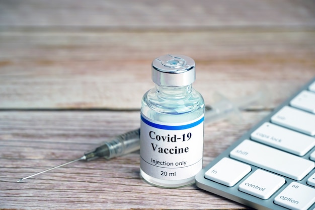 Coronavirus vaccine bottle with keyboard Coronavirus vaccine online booking