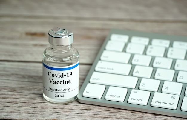 Coronavirus vaccine bottle with keyboard Coronavirus vaccine online booking