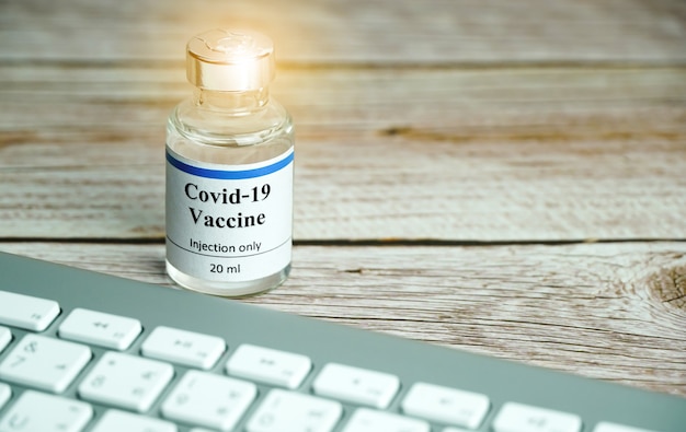 Coronavirus vaccine bottle with keyboard Coronavirus vaccine online booking