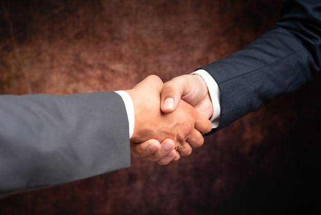 Corporate Businessmen Handshake Indoors.Two People Professionally Well Dressed Gesturing Togetherness.Working Colleague Partners Sign Deal In Agreement To Contract