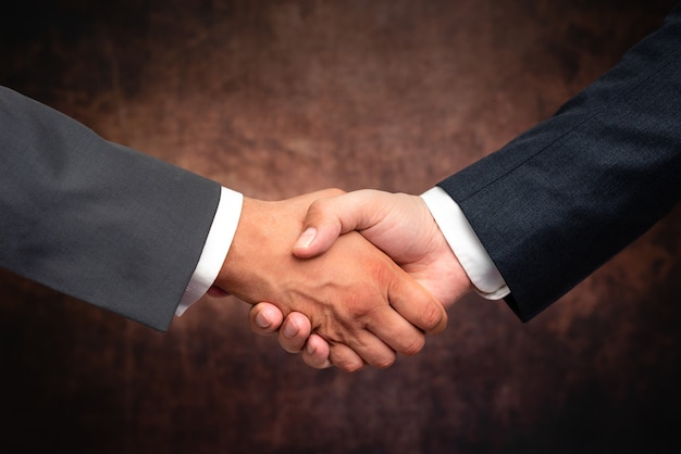 Corporate Businessmen Handshake Indoors.Two People Professionally Well Dressed Gesturing Togetherness.Working Colleague Partners Sign Deal In Agreement To Contract