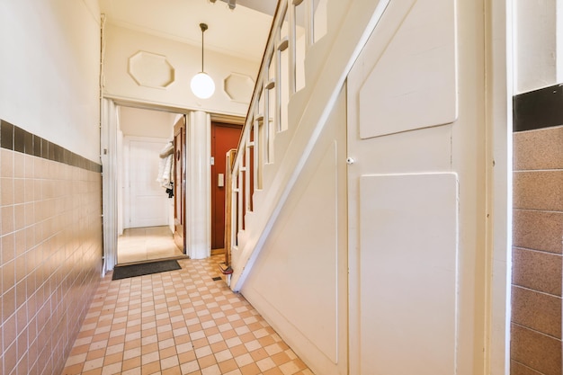 A corridor leading inside the apartment with a straight staircase leading up