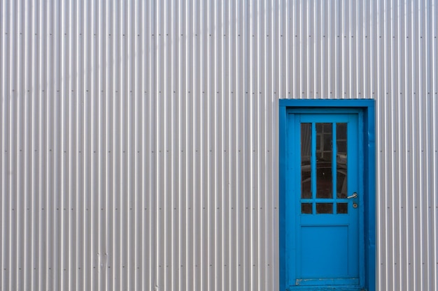 Corrugated metal wall house with colorful door