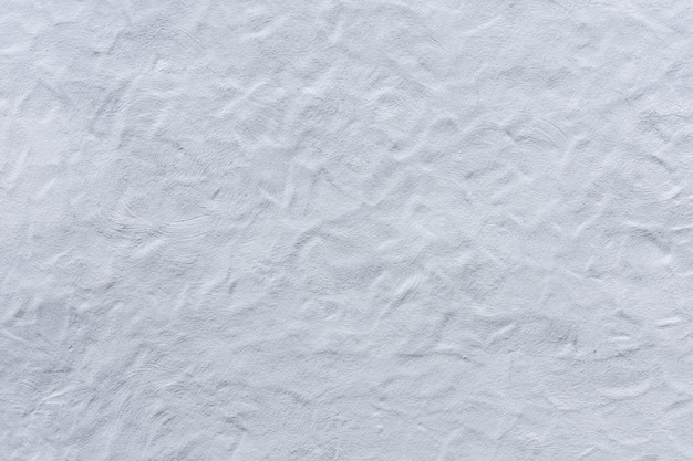 Corrugated plaster from a white wall of a castle