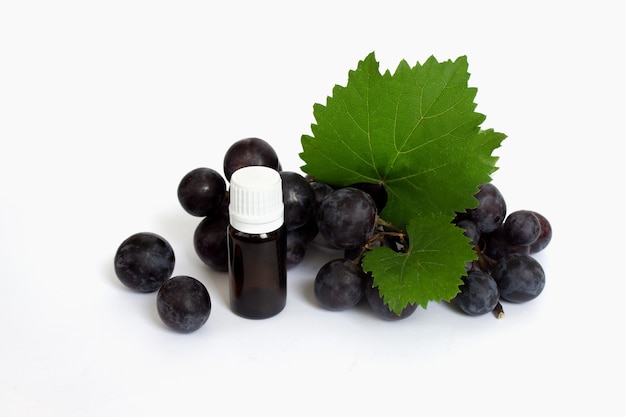 Cosmetic bottle and purple grapes on white background cosmetic