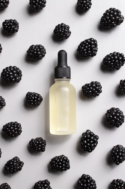 Cosmetic bottle of serum and blackberries Essential oil collagen serum for beauty Cosmetics with natural ingredients