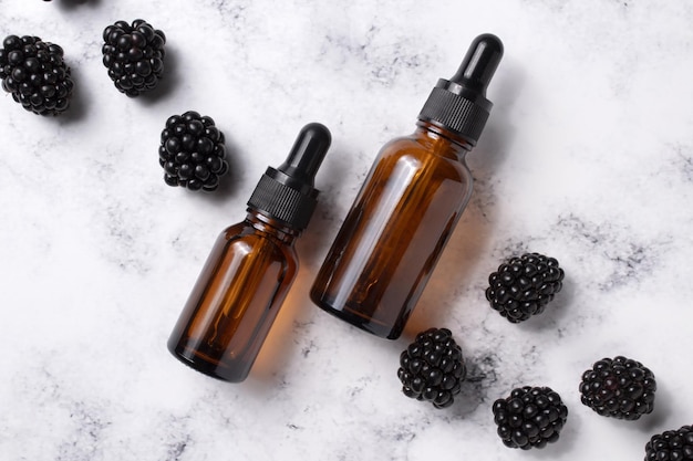 Cosmetic bottle of serum and blackberries Essential oil collagen serum for beauty Skin care cosmetic Beauty concept for face body care