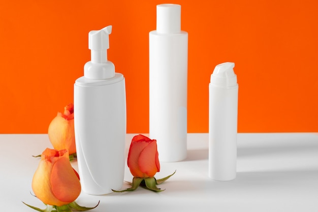 Cosmetic bottles with rose petals, copy space