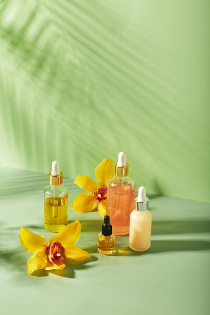 Cosmetic care products in glass bottles with orchid flowers serums cream gel oils Concept for face and body care wellness and spa tropical relaxation