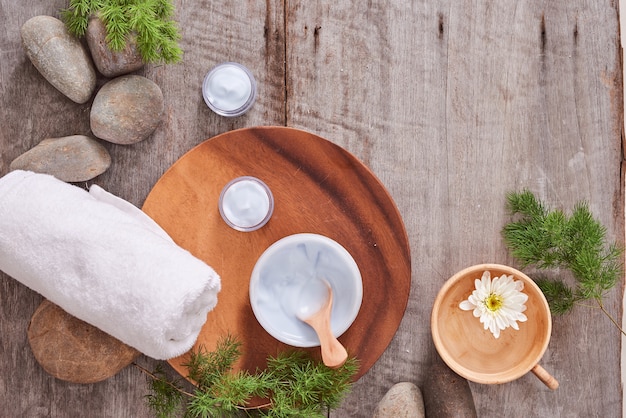 Cosmetic cream and fresh lavender leaves on white wooden table background