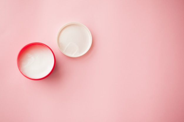 Cosmetic cream in a red jar on a pink background. skin care. 