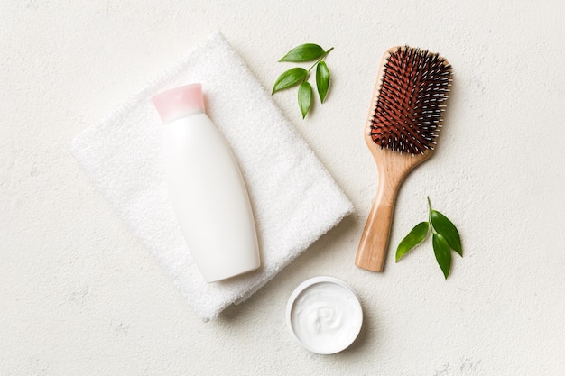 Cosmetic for hair care cream and towel on a colored background top view flat lay