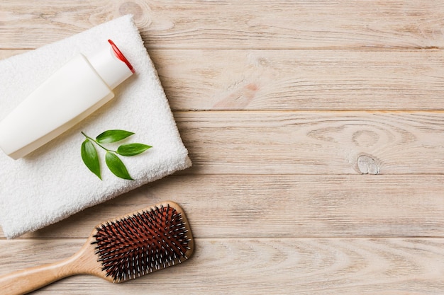 Cosmetic for hair care cream and towel on a colored background top view flat lay