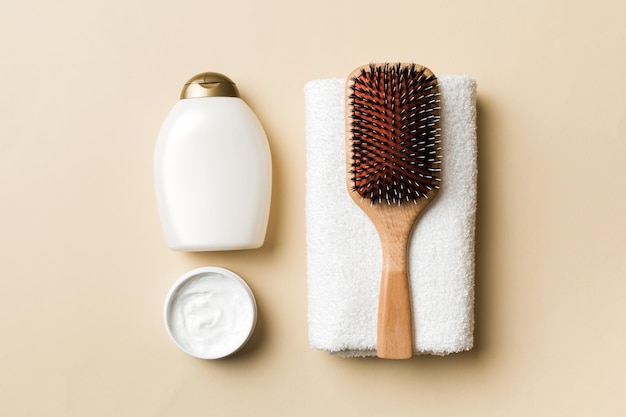 Cosmetic for hair care cream and towel on a colored background top view flat lay