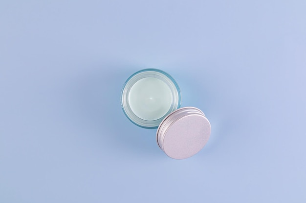 cosmetic jar with natural selfcare cream on blue background Top view A copy space Natural cosmetics packaging presentation mockup