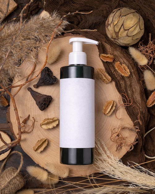 Cosmetic one pump bottle on wood near natural boho decorations top view Label Mockup