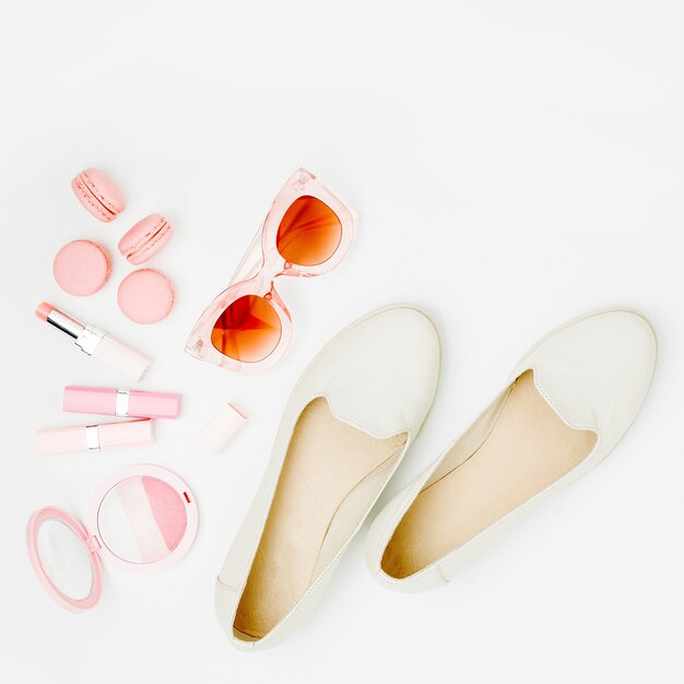 Cosmetic products, sunglass, shoes on white background. Flat lay, top view. Fashion concept