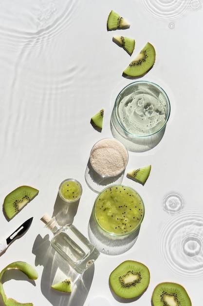 Cosmetic skincare background. Herbal medicine with kiwi slices and palm leaves. Homemade sugar scrab. Natural sunlight, long shadows. Splashes, water circles. Natural skincare background.