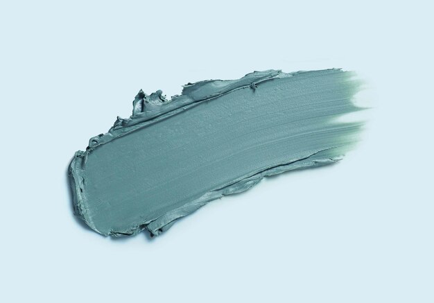 Cosmetic smeared creamy liquid eye shadow or liner swatch on blue background