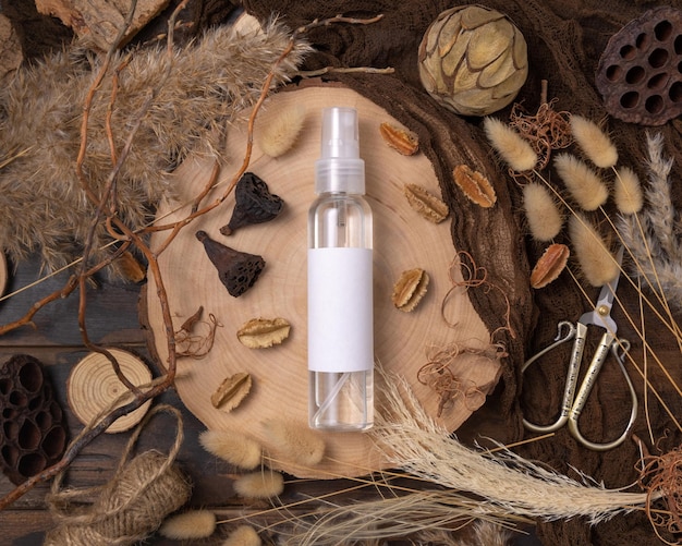 Cosmetic spray bottle on wood near natural boho decorations top view Label Mockup