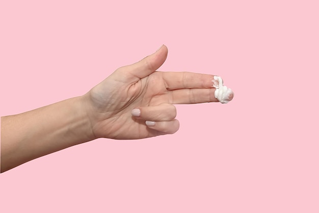 Cosmetic white cream on the fingers of a female hand Skin care concept